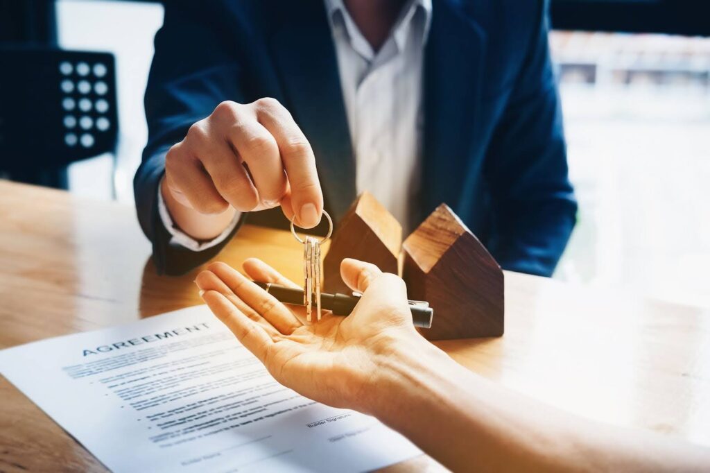 A real estate agents agree to buy a home and give keys to clients at their agency's offices